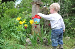 Kinder im Garten: Wasserspiel mit Gießkanne