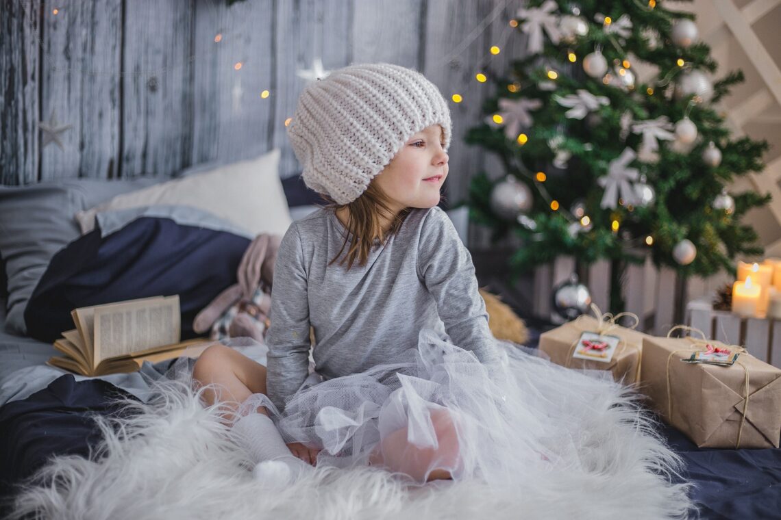 Zweifel am Wichtel: Kind mit Geschenken unterm Weihnachtsbaum